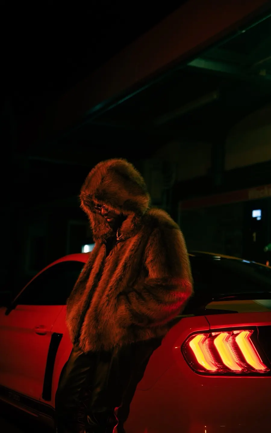 Artist im Fellmantel vor einem roten Mustang – entstanden bei einem Recap-Visuals-Dreh