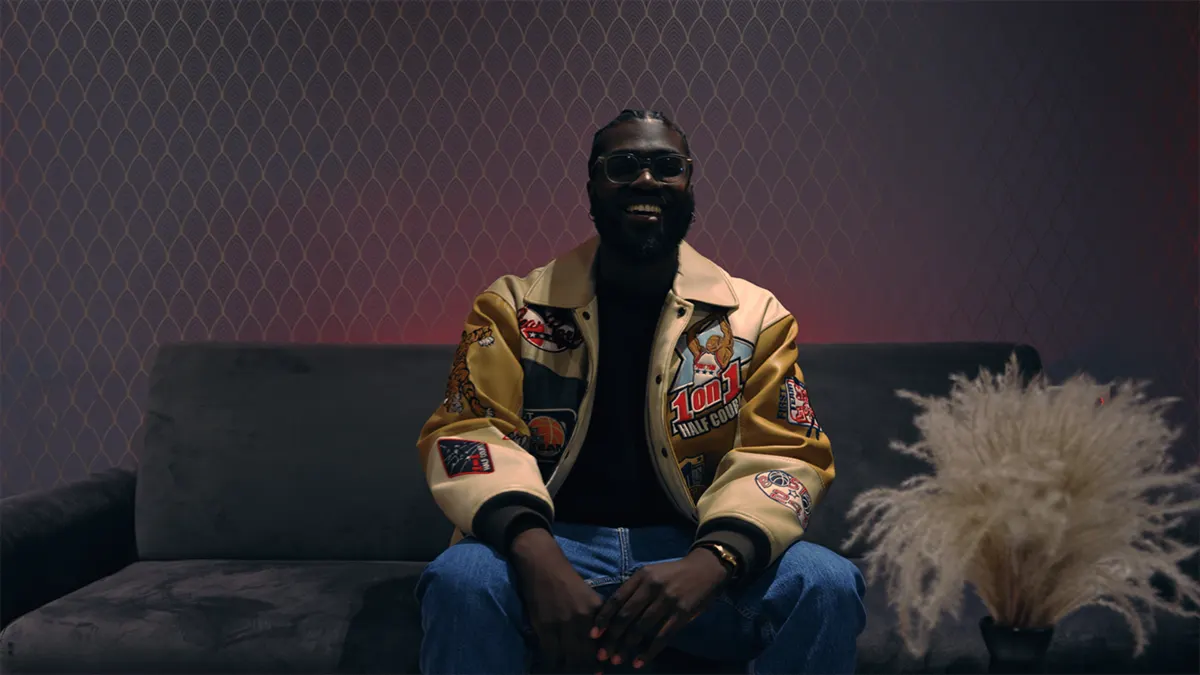 Artist im Interview auf einem Sofa – Still aus dem Testimonial-Video